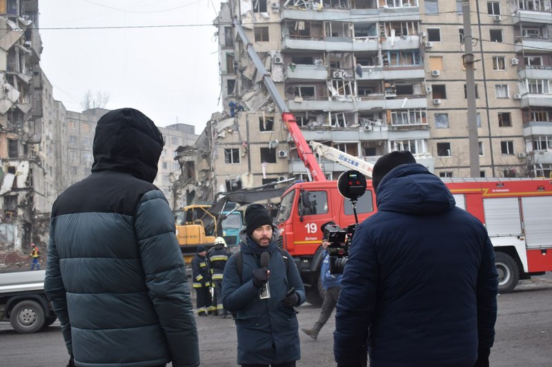 Журналисты работают возле жилого дома, разрушенного российской ракетой. Днепр, январь 2023 г. Фото: Алесь Минов